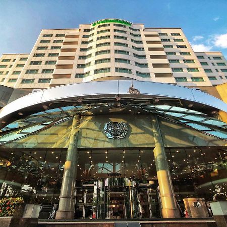 Evergreen Laurel Hotel - Taichung Exterior foto The photo shows the exterior of a modern hotel building. The entrance features a large, glass canopy supported by columns, creating a welcoming area. The facade of the hotel is composed of a mix of glass and concrete, with large windows that suggest 