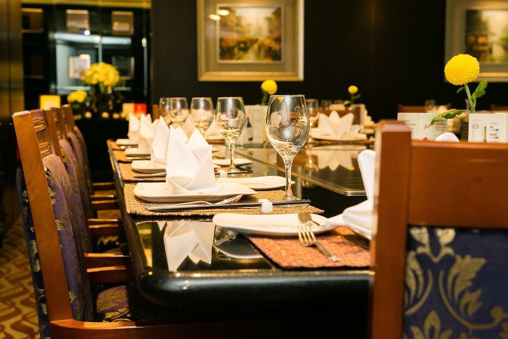 Evergreen Laurel Hotel - Taichung Exterior foto The photo depicts a dining table set for a formal meal. The table is long, covered with a dark tablecloth, and has neatly arranged plates, forks, and glasses at each setting. White napkins are folded elegantly, and there are small yellow flowers as c