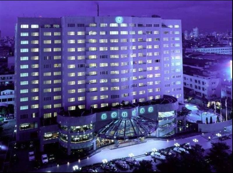 Evergreen Laurel Hotel - Taichung Exterior foto The photo shows a large hotel building illuminated in a purple hue during the evening or nighttime. The facade features numerous windows, many of which are lit, suggesting occupancy. The entrance area appears modern and curved, with a design that inc