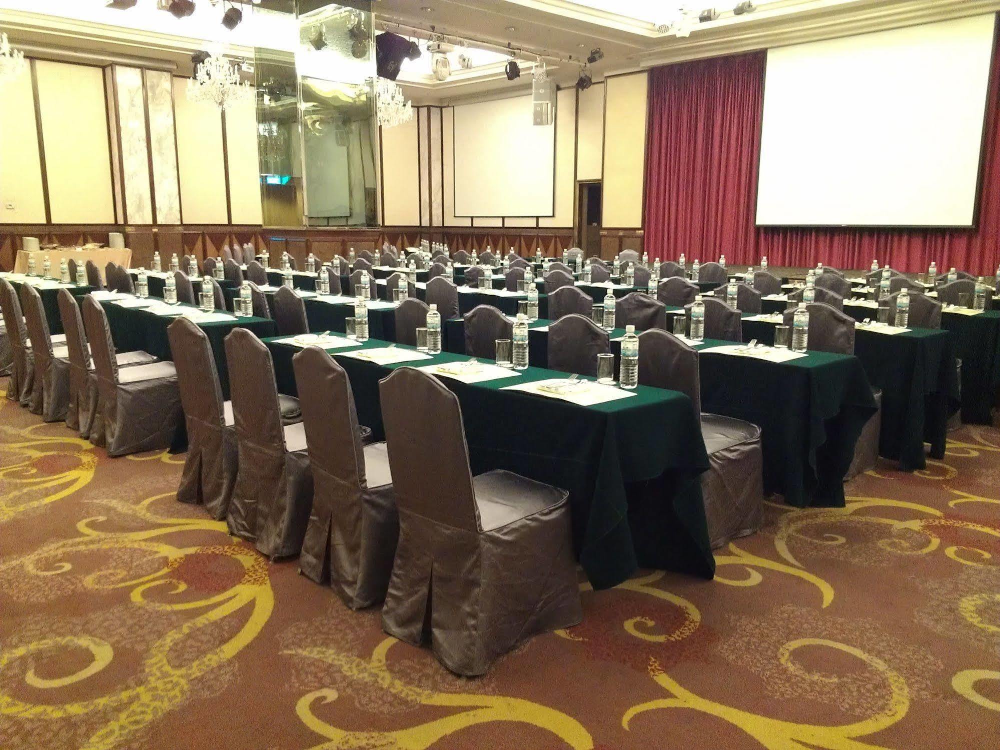 Evergreen Laurel Hotel - Taichung Exterior foto The photo shows a large conference or meeting room set up with multiple tables arranged in a structured manner. Each table is covered with a tablecloth, alternating between black and green. There are chairs around each table, and each place setting a