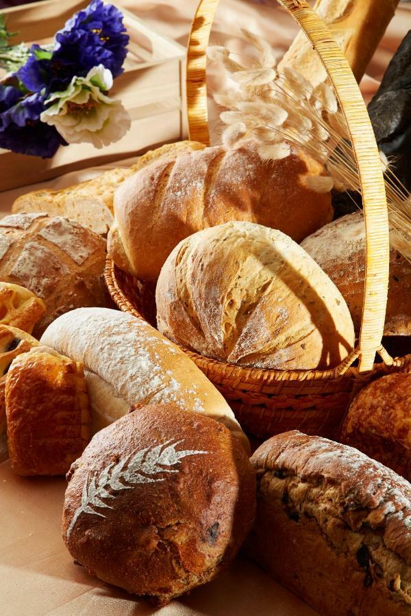 Evergreen Laurel Hotel - Taichung Exterior foto The photo shows a variety of freshly baked bread arranged in a woven basket. There are different types of bread, including round loaves, baguettes, and crusty rolls, showcasing a range of colors and textures. Some loaves have distinctive patterns or 