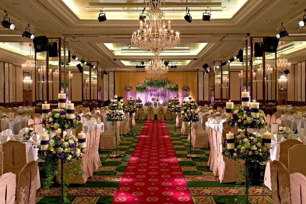 Evergreen Laurel Hotel - Taichung Exterior foto The photo shows an elegantly decorated banquet hall set up for a wedding or formal event. The center aisle is lined with rows of elegantly draped chairs and features a bright red carpet. On either side of the aisle, there are beautifully arranged flo