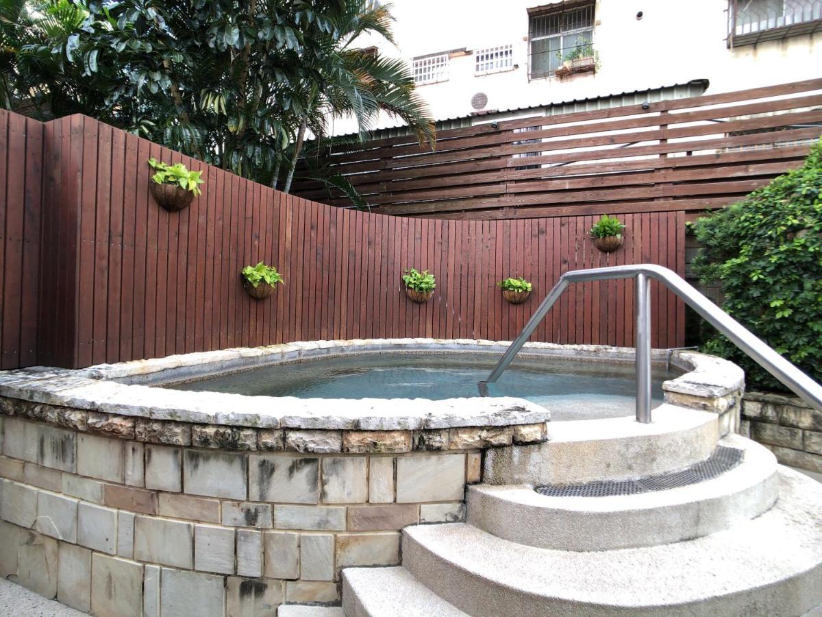 Evergreen Laurel Hotel - Taichung Exterior foto The photo shows a small outdoor hot tub or spa area. It's surrounded by a wooden fence, with several planters containing greenery attached to the wall. The hot tub is round, with a stone border, and there are steps leading up to it with a stainless s